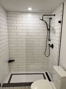Renovated bathroom with a walk-in shower and tiled walls