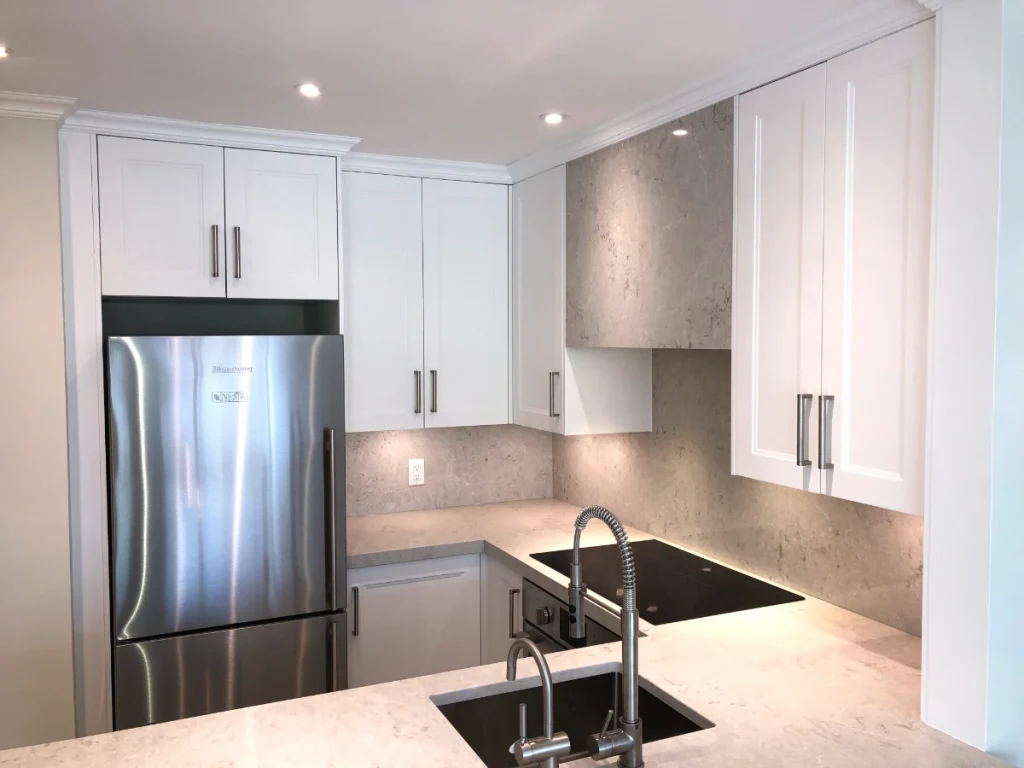Renovated kitchen with white cabinets and new countertops.