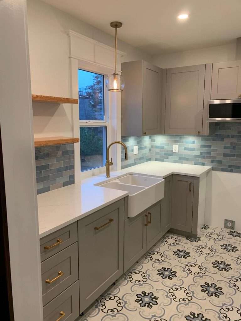 Renovated kitchen with grey cabinets, quartz countertops and new spanish tiles.