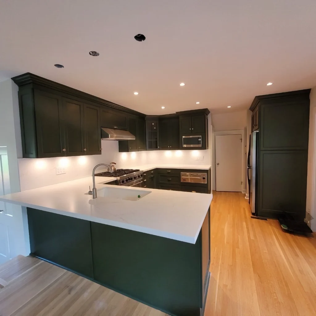 Kitchen in a home space with green cabinets and white countertops